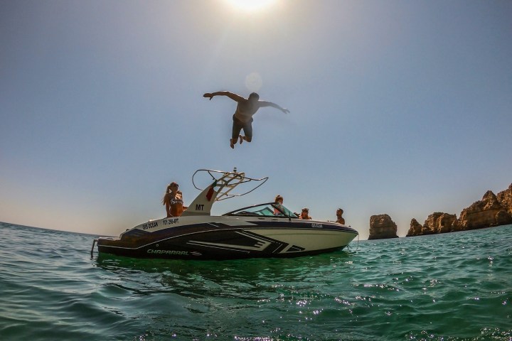a man riding on the back of a boat in the water