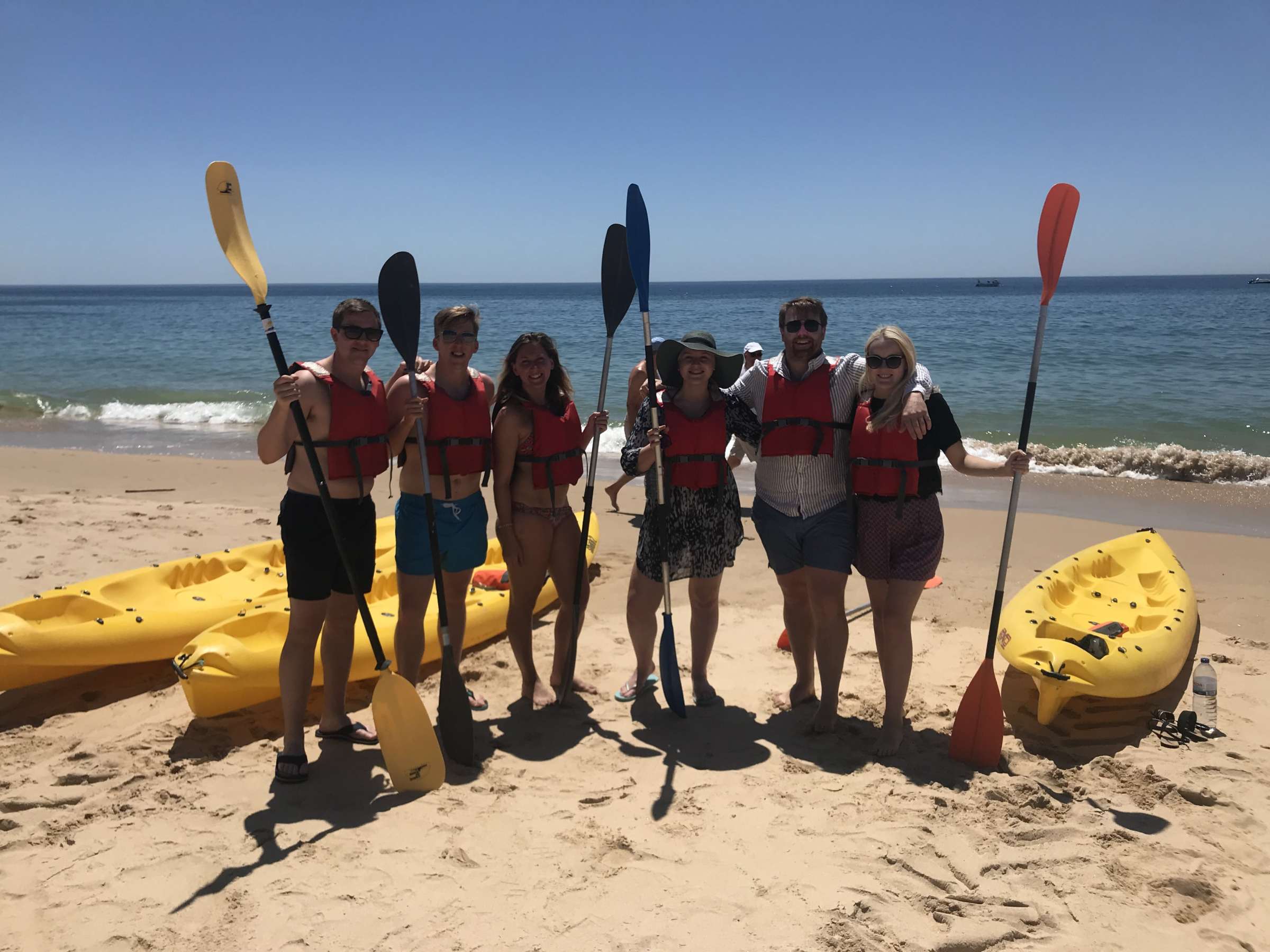 a group of people on a beach posing for the camera