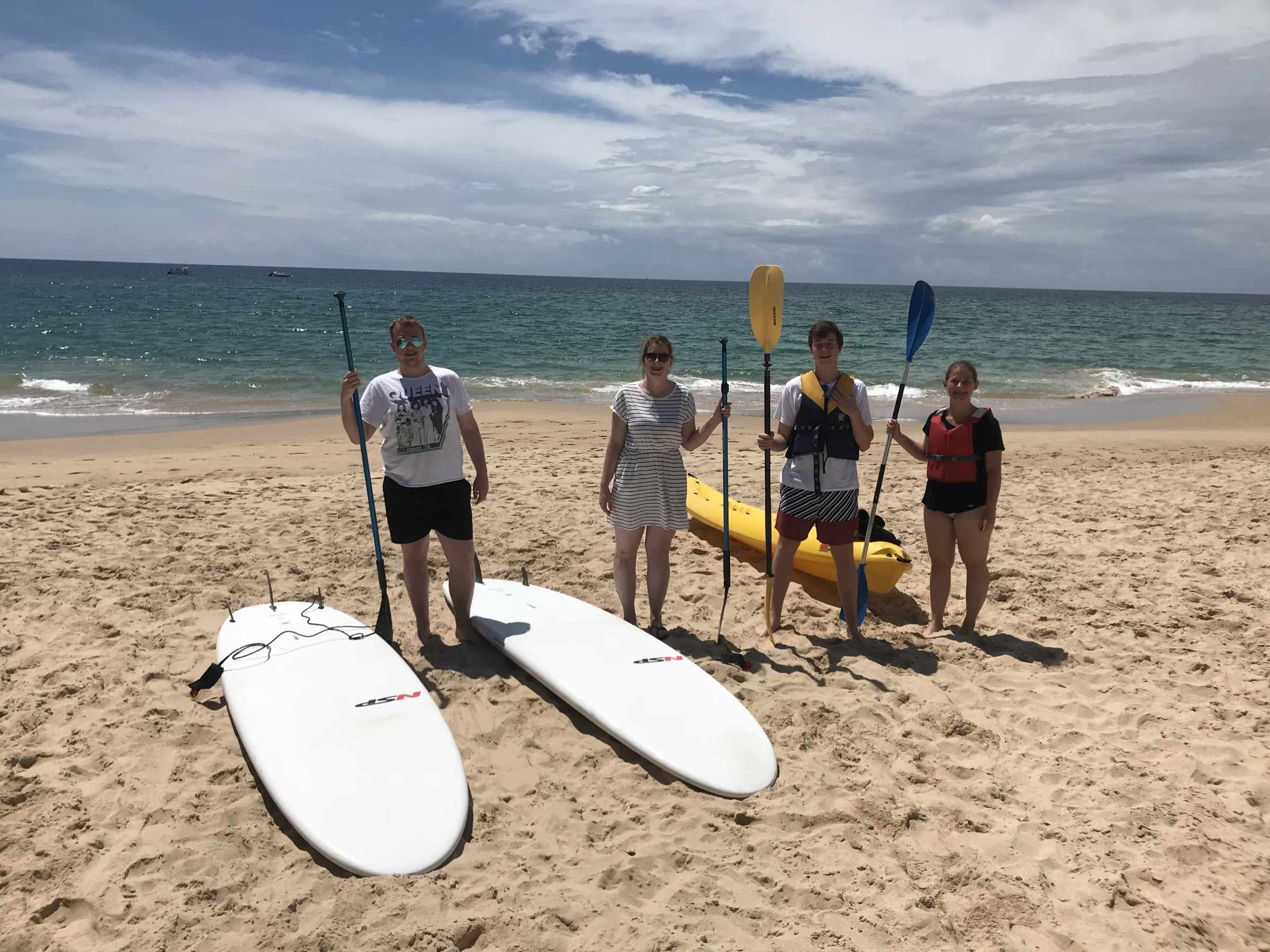 a group of people on a beach holding paddles