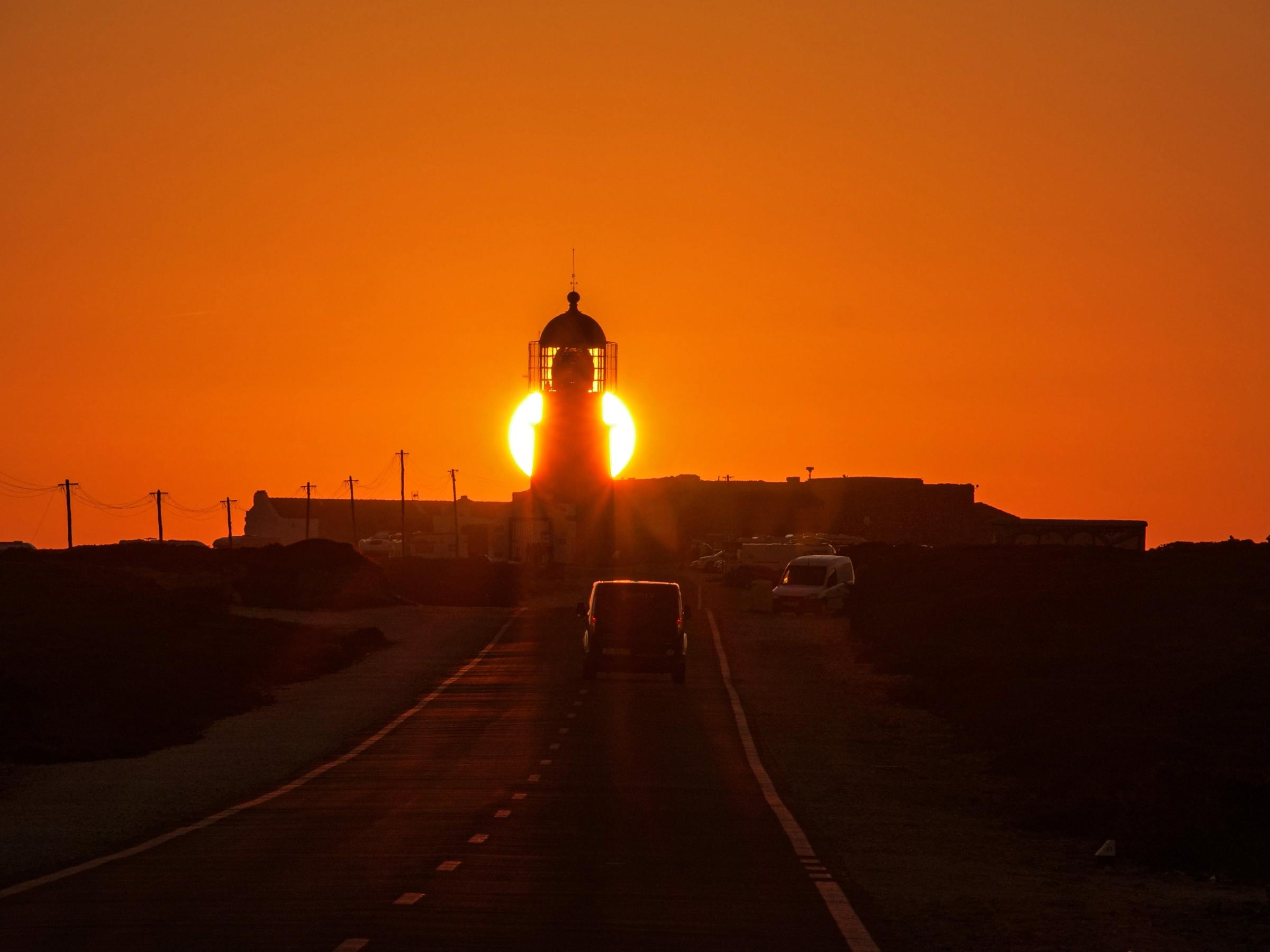 a sunset behind a lighthouse